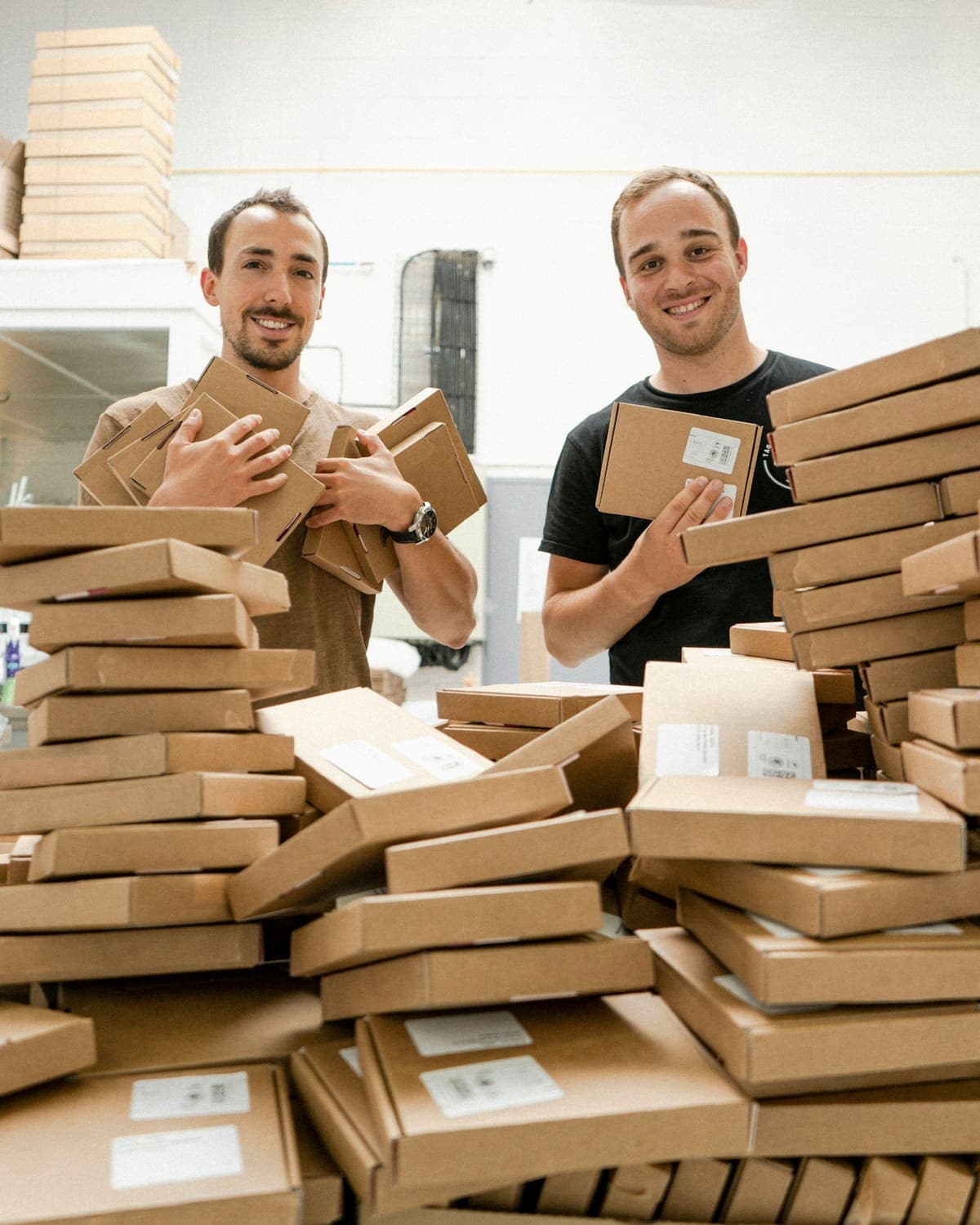 Two small business owners with a pile of orders packed and ready to post