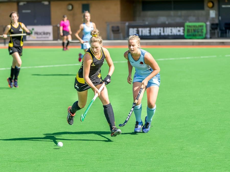 Hockey players chasing the ball on an artificial pitch