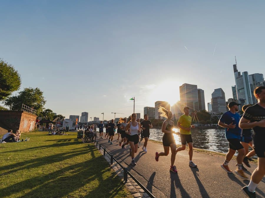 A group of runners on a riverside path at sunset