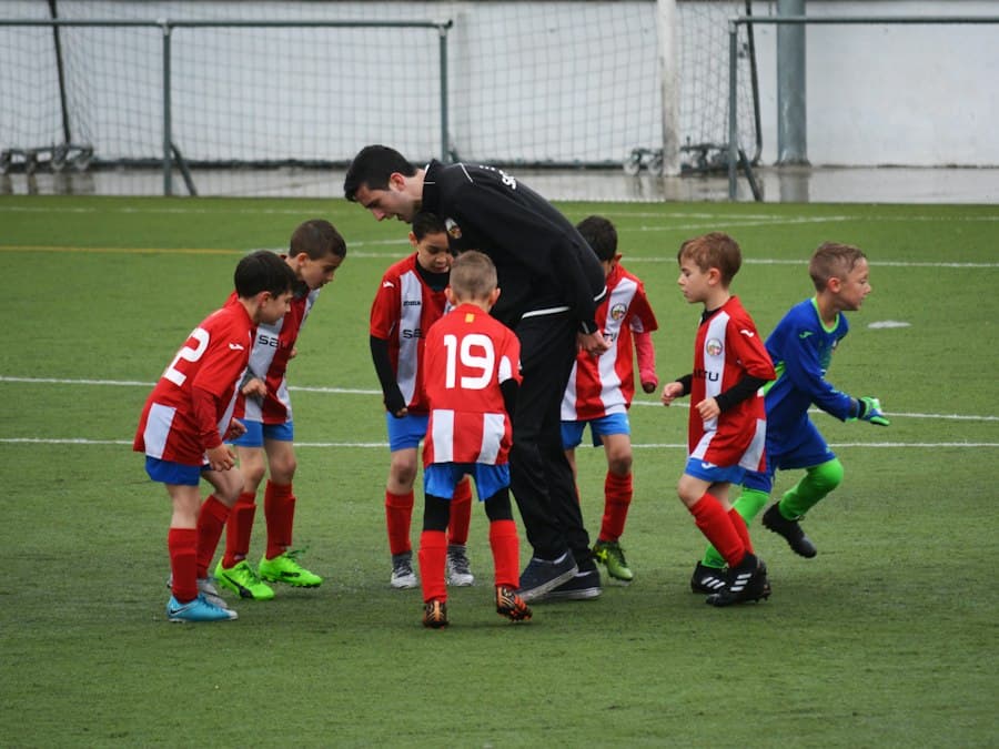 A coach with a young football team on the pitch